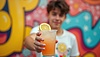 Young man holding refreshing lemonade against | Stock Illustration