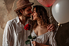 Happy couple holding red roses surrounded by | Stock Foto