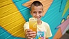 Young man holding refreshing lemonade against | Stock Foto