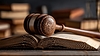 Wooden gavel and open law book on courtroom desk | Stock Foto