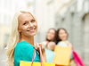 Hermosa mujer con bolsas de la compra en ctiy | Foto de stock