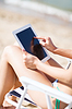 Girl looking at tablet pc on beach | Stock Foto