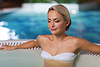 Happy womani sitting in jacuzzi at poolside | Stock Foto