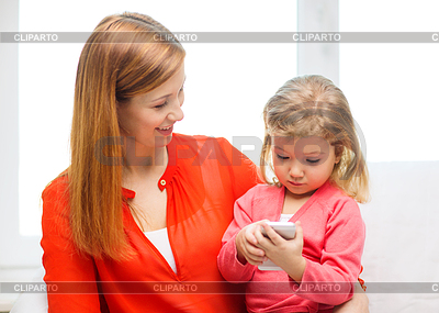 Happy mother and daughter with smartphone at home | High resolution stock photo |ID 4450133