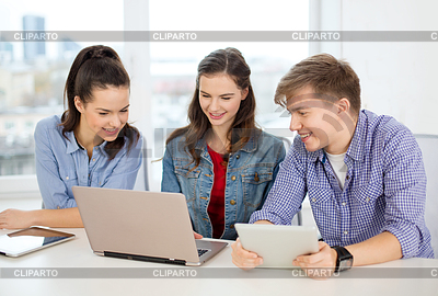 Tres estudiantes sonrientes con la computadora portátil y tablet pc | Foto de alta resolución |ID 4450837
