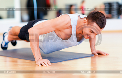 Hombre haciendo flexiones en el gimnasio sonriente | Foto de alta resolución |ID 4458904