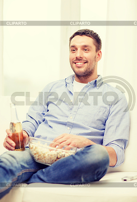 Lächelnden Mann mit Bier und Popcorn zu Hause | Foto mit hoher Auflösung |ID 4724442