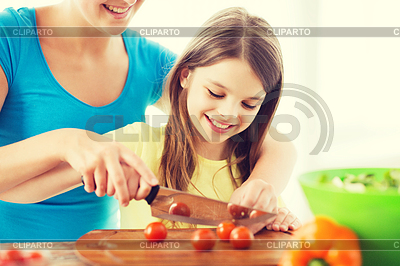 Smiling little girl with mother chopping tomatoes | High resolution stock photo |ID 4741430