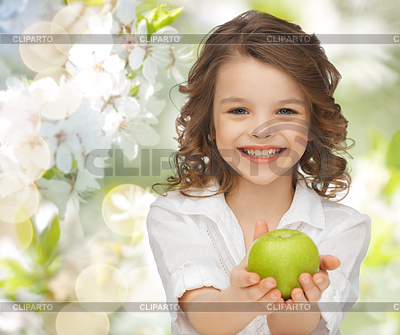 Happy girl holding apple over garden background | High resolution stock photo |ID 4932599