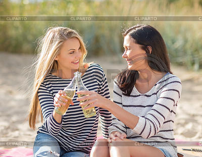 Glückliche junge Frauen trinken Bier am Strand | Foto mit hoher Auflösung |ID 4933223