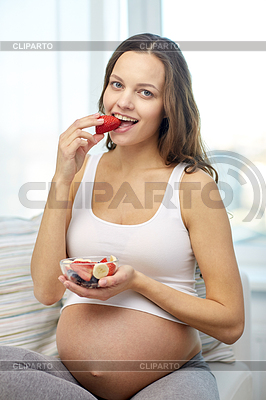 Happy pregnant woman eating fruits at home | High resolution stock photo |ID 4943832